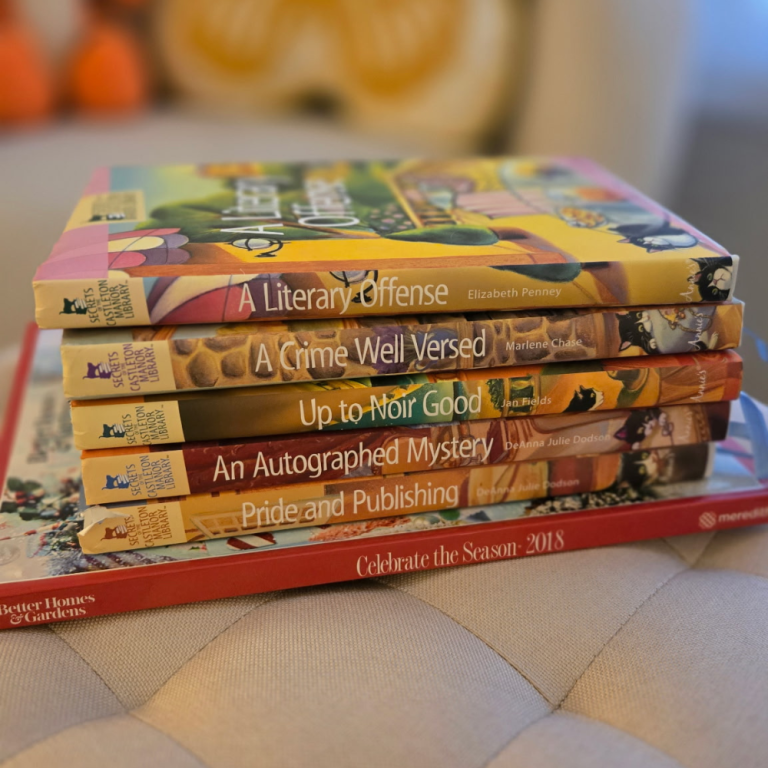 For Screen Readers: A photo of six books that Mia found at her local library. Five books are cozy mysteries with cats and one is a Christmas decorating book. #CozyCatLady